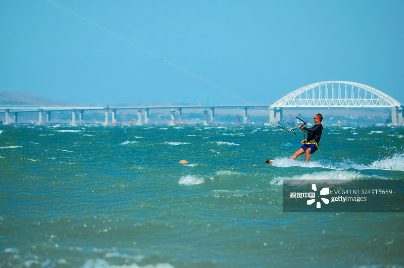 在夏日的蓝天背景下，在蓝色的大海上风筝冲浪图片素材