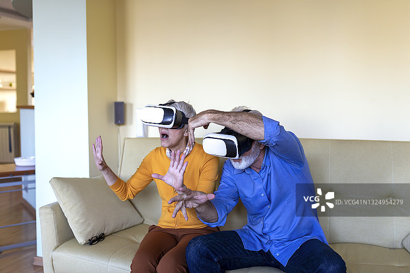 快乐的老年夫妇正在享受VR眼镜的乐趣。未来已经到来。图片素材