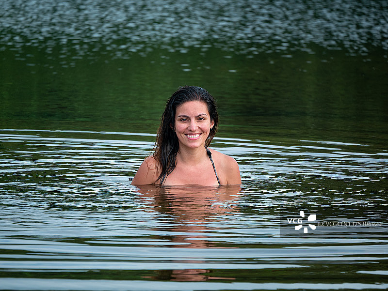 在哥伦比亚帕洛米诺的圣萨尔瓦多河上微笑的年轻拉丁女子图片素材