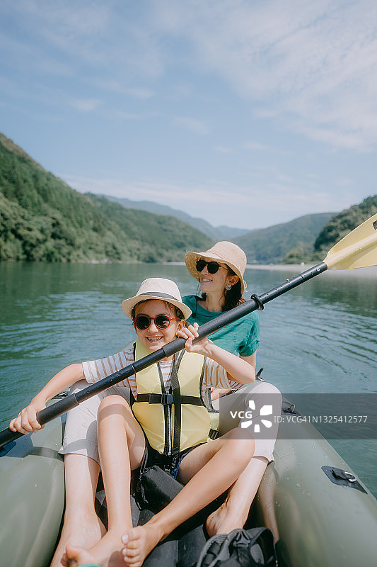 小女孩和她的母亲划着皮艇穿过日本的河流图片素材