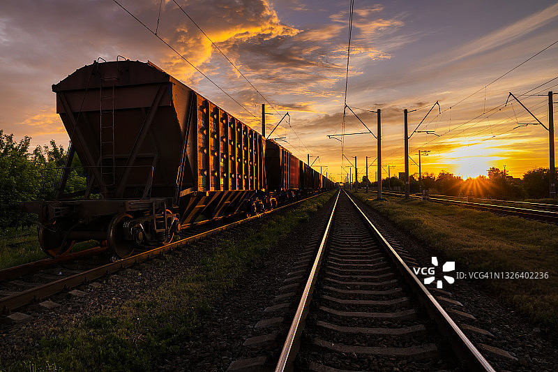 日落时铁路上的货车。铁路货运与客运图片素材