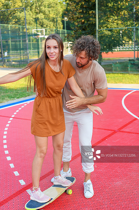 一对年轻夫妇在户外玩滑板。图片素材