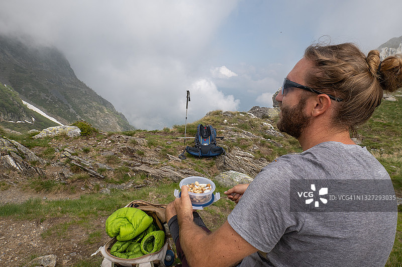 男性徒步旅行者会在山路上吃零食图片素材