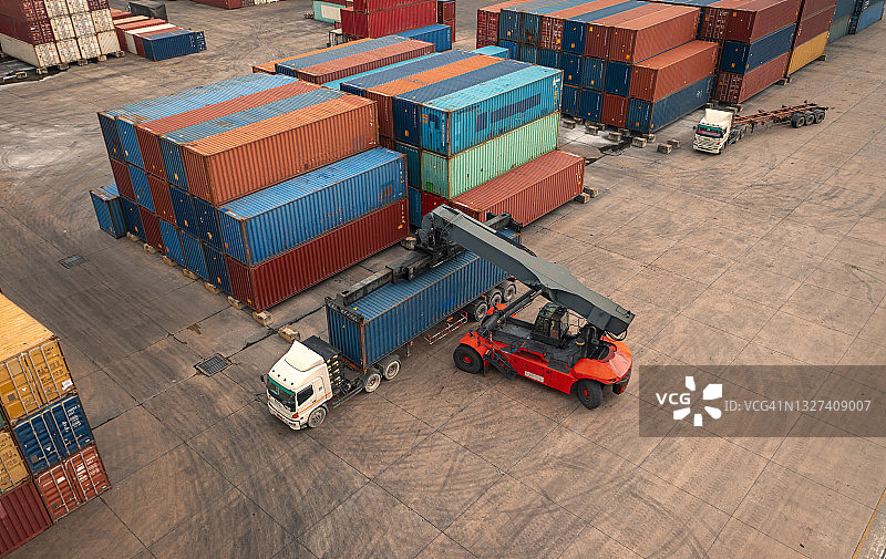 鸟瞰图:在配送仓库中，叉车将集装箱装到卡车，用于集装箱船，商务物流，进出口运输或货运运输。图片素材