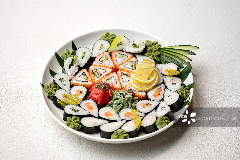 装寿司的盘子，白色背景上的卷。日本餐厅的食品。健康的东方餐。健康的概念。水平格式图片素材