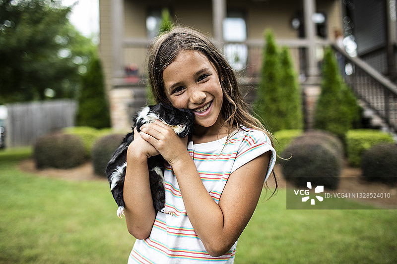 小女孩抱着天竺鼠在前院图片素材