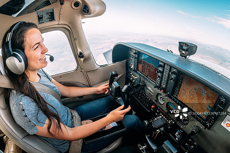 广角拍摄的快乐的年轻成年女性飞行员和飞行教官微笑和驾驶小型单引擎飞机图片素材