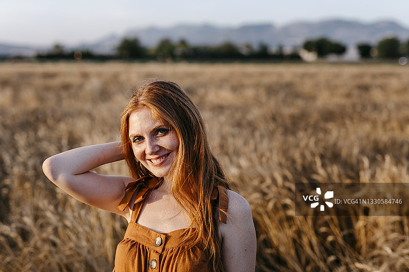 在农田里微笑的红发女人图片素材