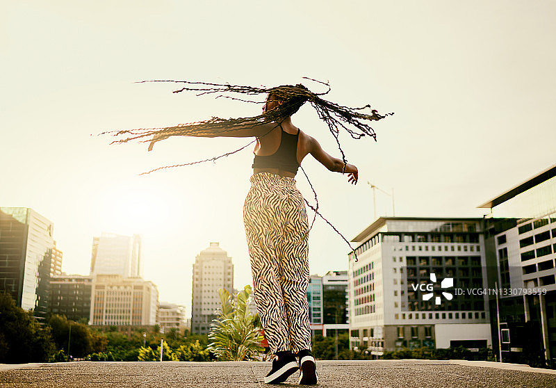 一个美丽的年轻女子在城市里跳舞图片素材