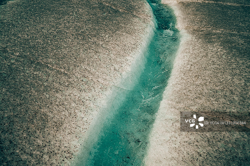 在加拿大落基山脉，一条绿松石色的河流穿过冰川图片素材