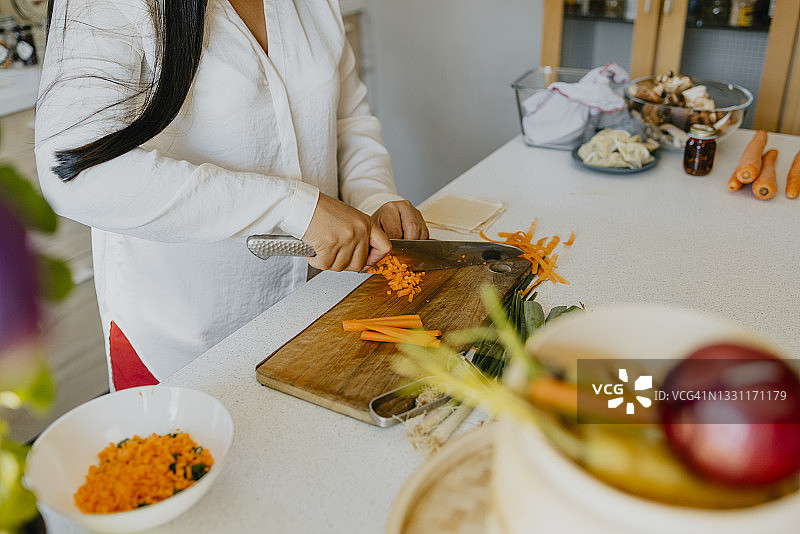 匿名女厨师在厨房准备美味的一餐图片素材