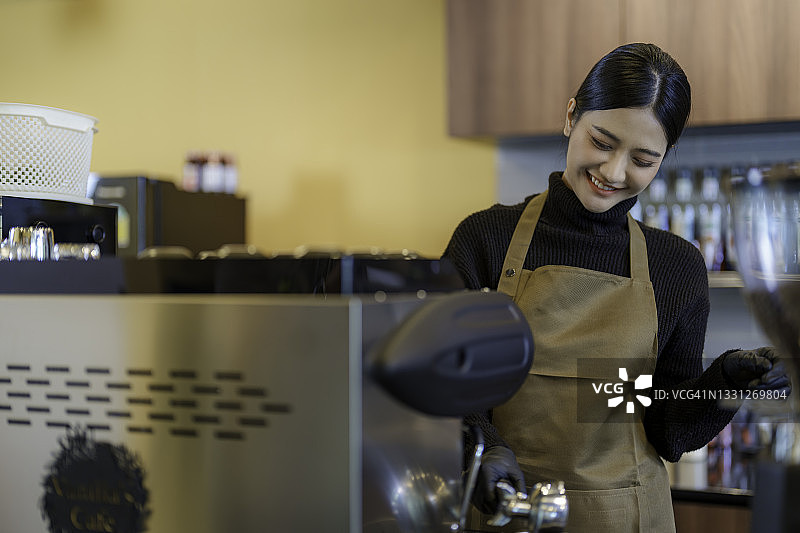 年轻女性女咖啡师为顾客在咖啡馆。图片素材