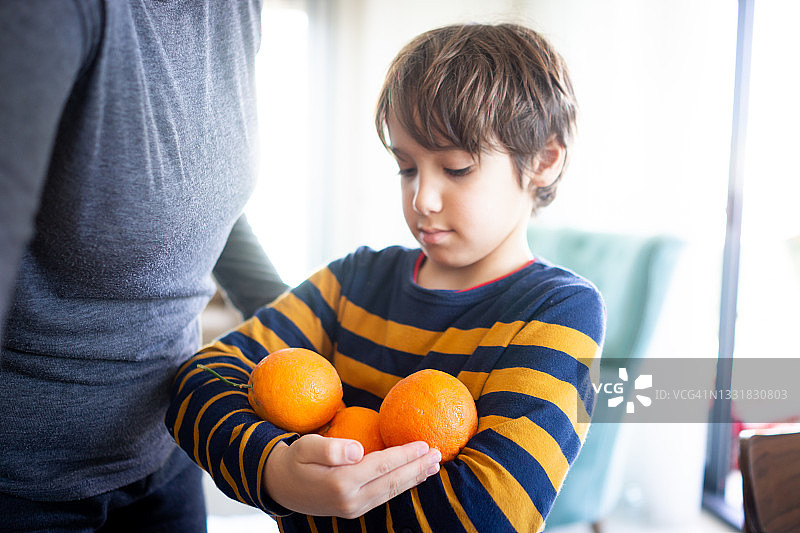 孩子在家里榨橙汁图片素材