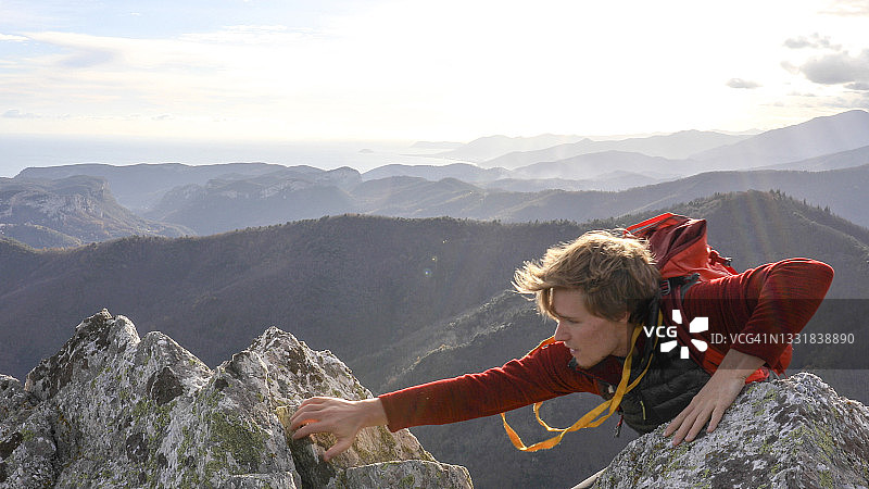 登山运动员爬上山顶图片素材