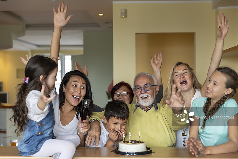 一位老人正在和其他家庭成员庆祝生日。图片素材
