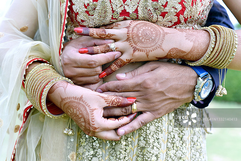 印度一对年轻夫妇拥抱并展示他们的结婚戒指的特写镜头图片素材