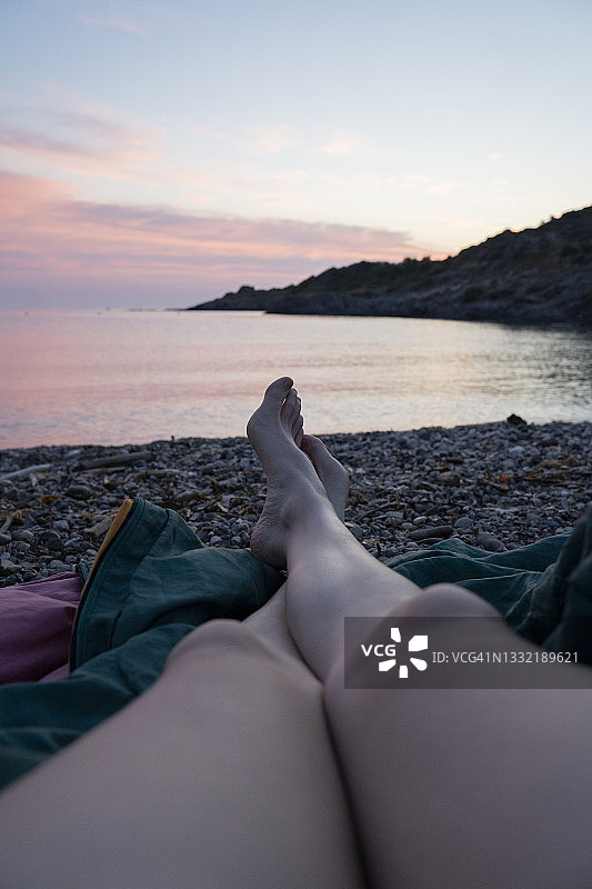 在沙滩上交叉双腿放松的女人图片素材