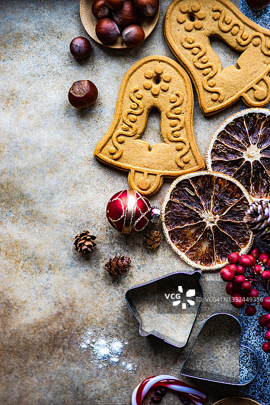 圣诞钟饼干，饼干切刀，坚果，干果和圣诞装饰在烤纸上图片素材