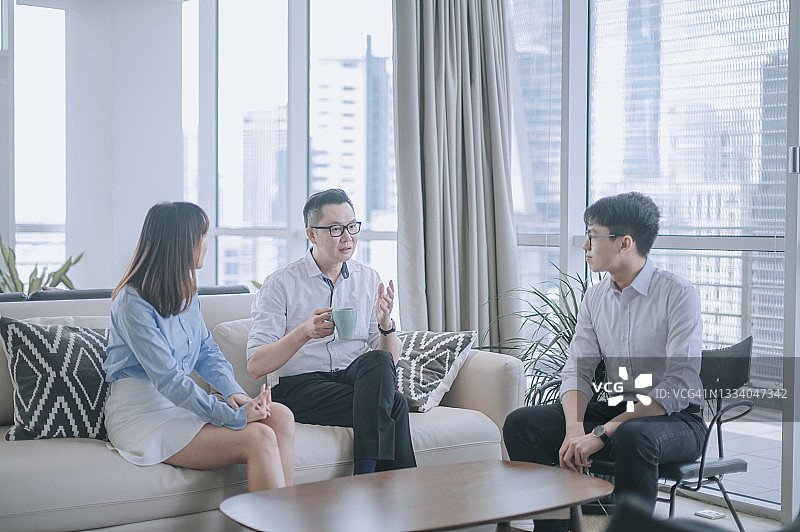 亚洲华人商务人士在办公室商务休息室沙发上闲谈图片素材