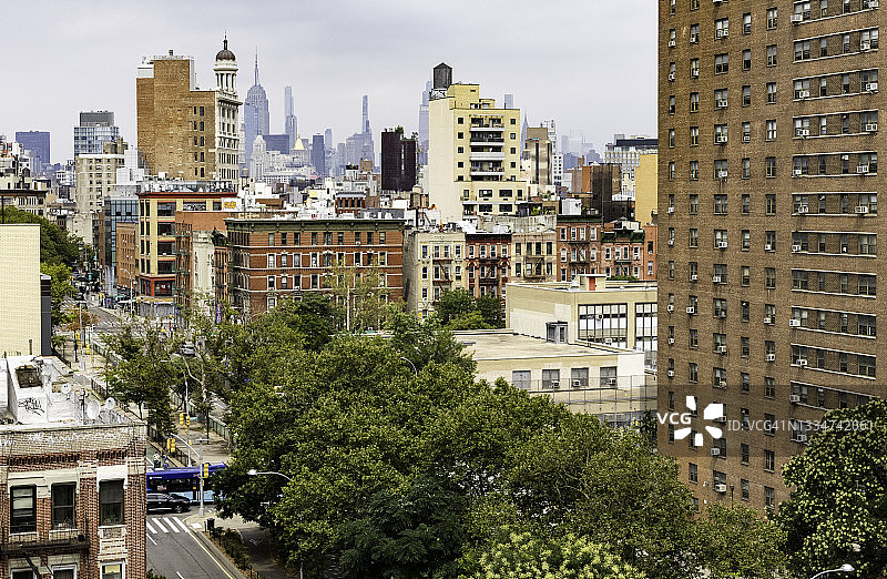 曼哈顿市中心(纽约市)的观点，摩天大楼在远处的树木和公寓大楼和商店的唐人街区在前景图片素材