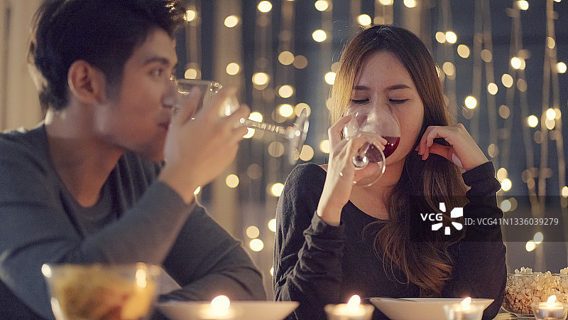 一对年轻夫妇在闪烁的灯光下喝着酒图片素材