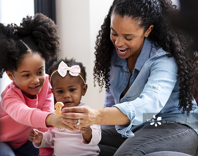 非裔美国母亲和女儿在和婴儿玩耍图片素材
