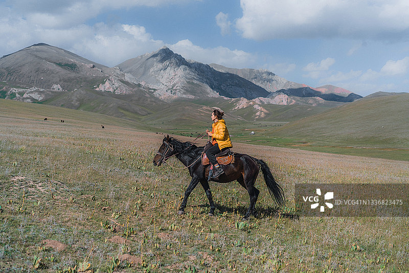 在吉尔吉斯斯坦山区骑马的女人图片素材