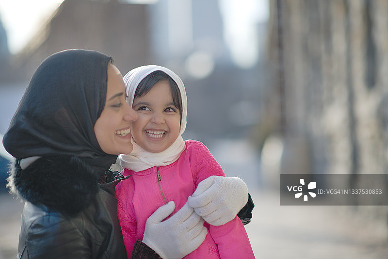 穆斯林母亲拥抱她的女儿图片素材