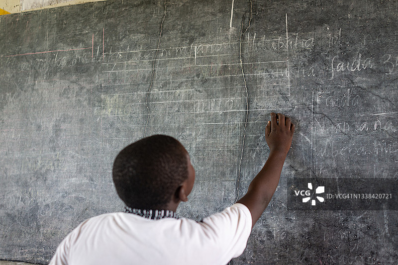 非洲孩子在学校黑板上写字图片素材
