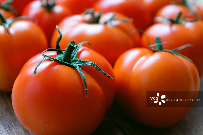 木桌上成熟的红番茄。素食，纯素食和生食食物和饮食。有机自制农产品。在菜园，菜园，郊区收获。食品的背景。图片素材