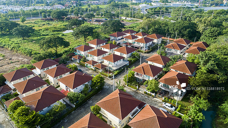 鸟瞰图的棕色屋顶的城镇住宅村与绿色的树茂密的叶子图片素材