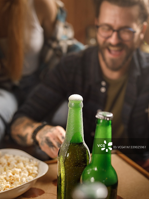 啤酒瓶和背景人物的特写。图片素材