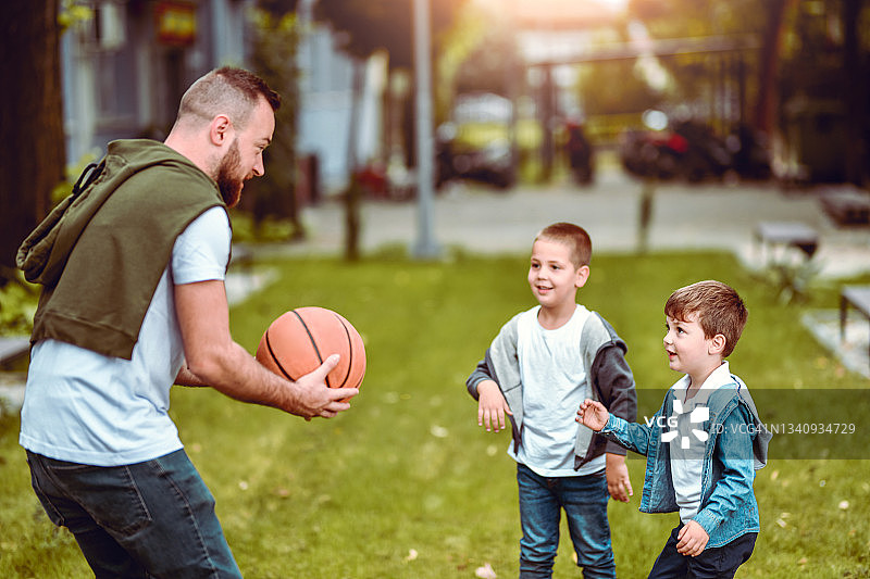 爸爸和儿子们在外面打篮球图片素材