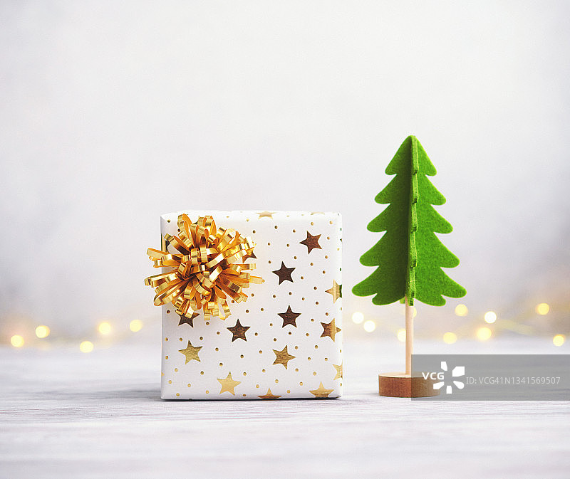 明亮的圣诞节背景与毛毡树和礼物在白色的木材图片素材