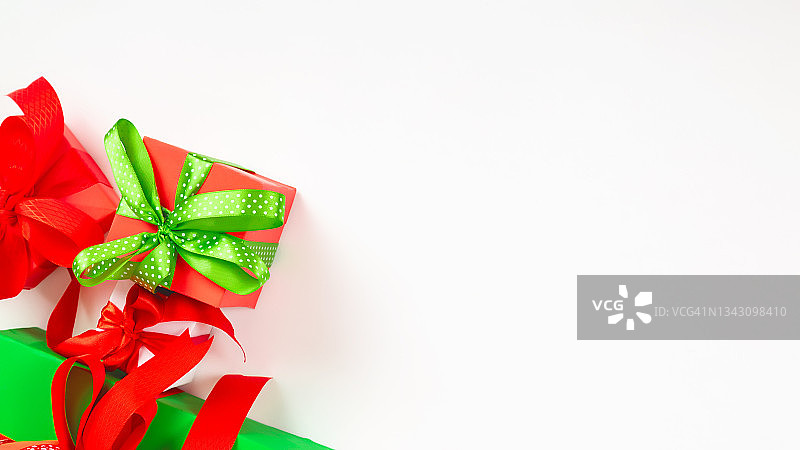 圣诞快乐和节日快乐贺卡。圣诞礼物和红色装饰在白色的背景顶部视图。新年的概念。平躺图片素材