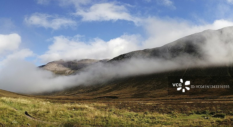 阳光普照的峡谷中低垂的云朵:苏格兰高地，凯恩戈姆斯图片素材