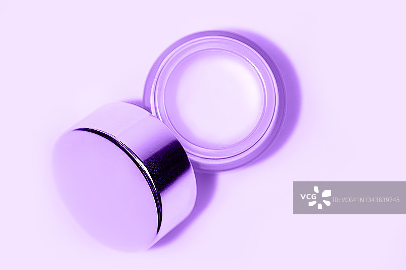 时尚的美容产品霜淡紫色背景。图片素材