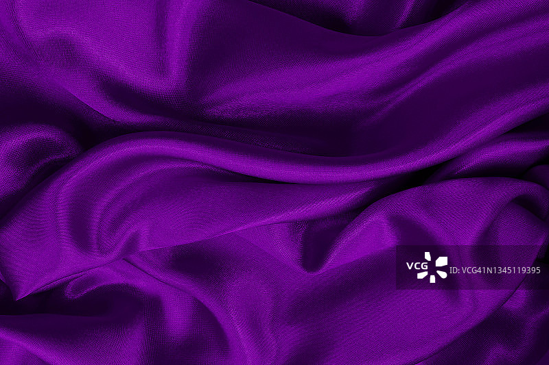 紫色面料的布料质地为背景和设计艺术作品，美丽的皱巴巴的丝绸或亚麻布图案。图片素材