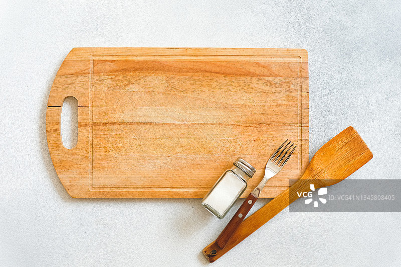 木制的抹刀，砧板，叉子和盐瓶在餐桌或厨房的桌子上。在餐馆和咖啡馆里烹饪，在家里的厨房里烹饪。自己动手做，学习如何烹饪美味佳肴的课程。副本的空间。图片素材