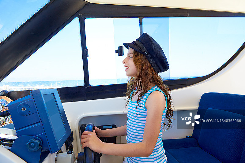 小女孩在船上装成船长，戴着水手帽图片素材