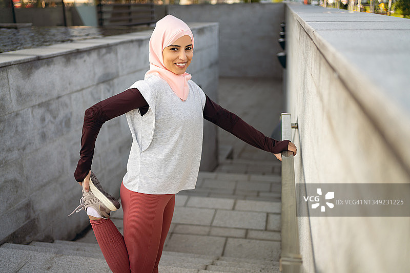 穆斯林田径女运动员伸展她的腿图片素材
