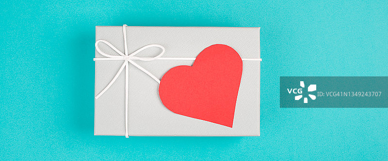 礼品盒有一颗红色的心，复制空间的文字，蓝色的背景，情人节，生日图片素材