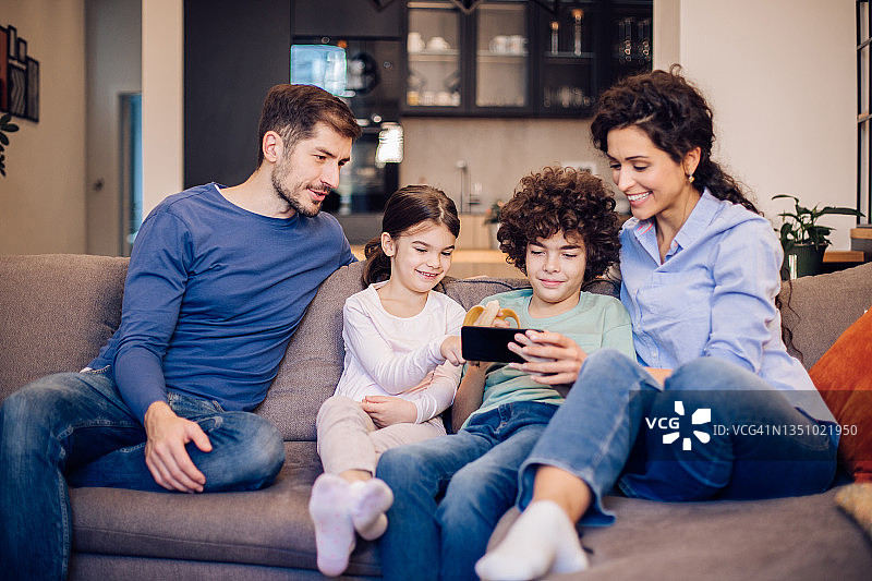 幸福的家庭一起玩智能手机图片素材
