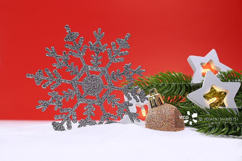 银光闪闪的雪花与星形灯笼和绿色云杉树枝和闪亮的球在红色的背景。圣诞节,新年。本空间图片素材