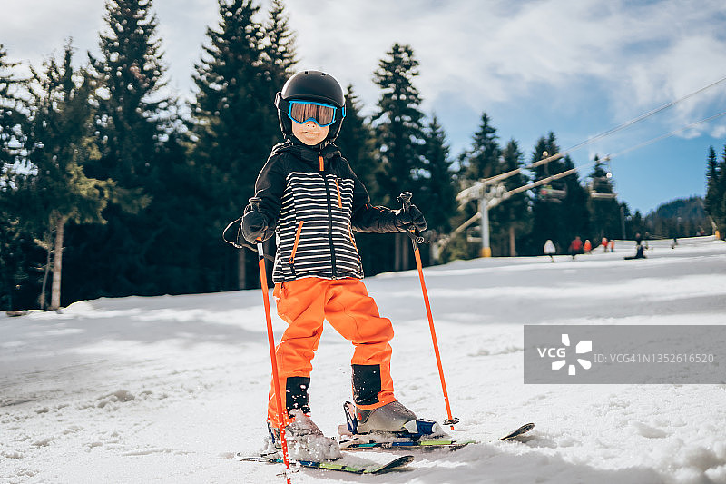 微笑可爱的男孩在滑雪。图片素材