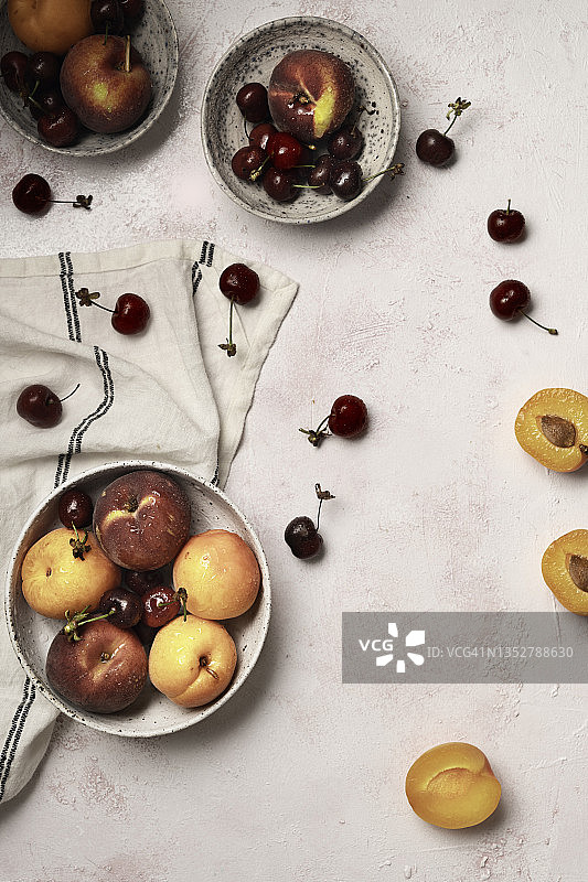 碗杏，桃子和樱桃在白色的背景图片素材