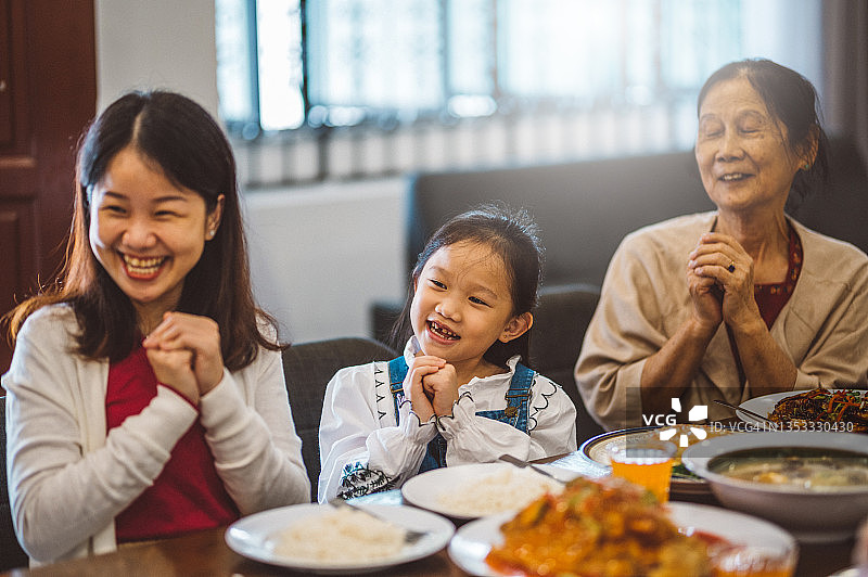 快乐的亚洲家庭在网上祝贺中国新年，并在家里通过视频电话与亲戚们团聚在一起吃团圆饭图片素材
