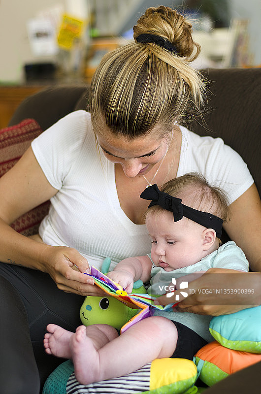 年轻母亲与婴儿一起阅读图片素材