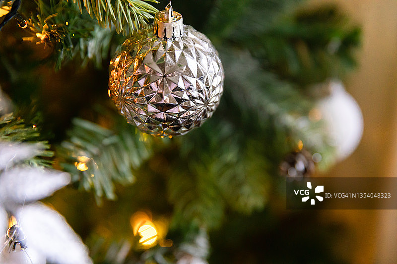 经典的圣诞装饰新年树。圣诞树有白色和银色的装饰，装饰玩具和球。现代古典风格室内设计公寓。平安夜在家图片素材