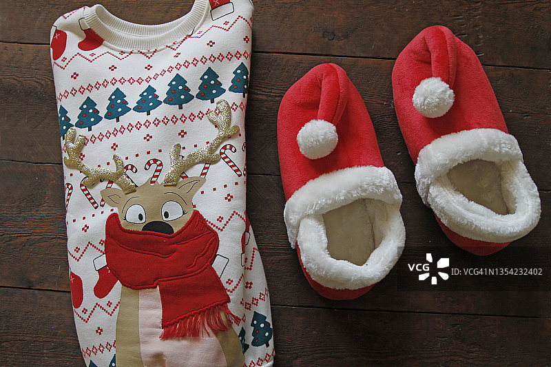 木制背景上的圣诞毛衣和拖鞋图片素材